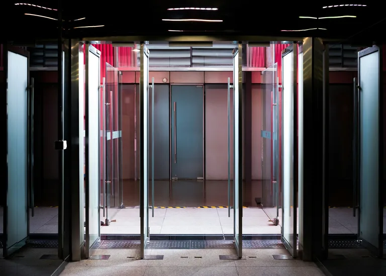 Glass revolving doors with modern interior lighting